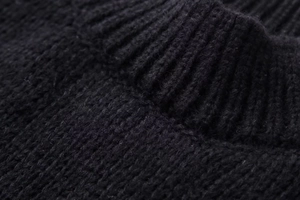 Detailed macro view of the ribbed round neckline on this premium black knit sweater