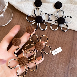 Détails de boucles d'oreilles fleurs en tissu léopard avec pétales texturés et bouton