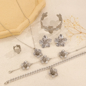Detailed view of a silver flower jewelry set with necklace, bracelets, and rings