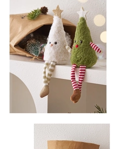 Detail view of plush Christmas tree dolls with long striped legs on a warm festive background