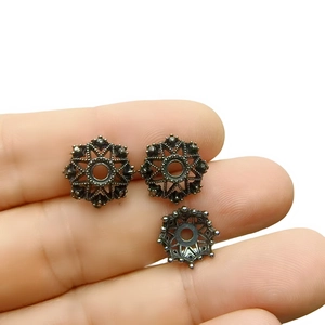 Macro detail of three vintage hollow patterned alloy flower caps for DIY jewelry