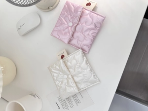 Detailed view of pink heart quilted satin storage bags with white snap button closure