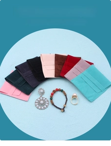 Flat lay of colorful velvet jewelry pouches with flap closure showing multiple color options
