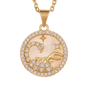 Macro shot of Scorpio gold pendant with mother-of-pearl and sparkling crystals