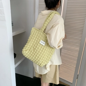 Fashionable bubble textured tote bag worn by a model in a minimalist home setting