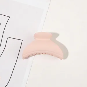 Detail view of the matte pink hair claw clip featuring non-slip resin teeth and sleek design
