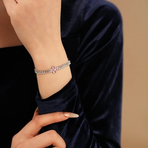 Detail of zircon clover bracelet with baguette crystals on rose gold plating