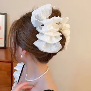 White layered organza hair claw clip for thick hair, showing elegant side view on brown hair