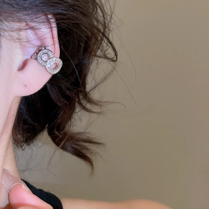Close-up of silver zircon ear cuff with interlocking circles on model's ear