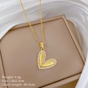 Detailed view of a gold heart pendant with sparkling pavé crystals and size parameters