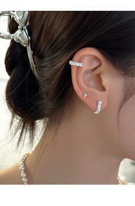 Detailed view of silver S925 earrings set with white zircon on model's ear