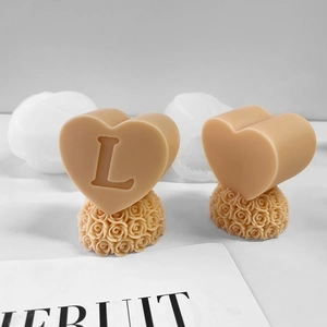 Macro shot of heart shaped soap mold with rose base and letter L engraving
