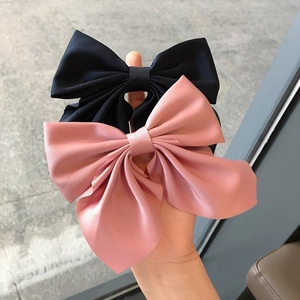 Pair of elegant satin bow hair clips in black and pink for women's hair styling