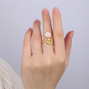 Détail de bague en acier inoxydable 18k avec fleur en nacre et pétale doré ajouré