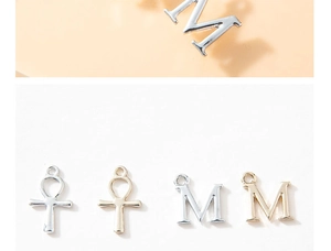 Macro detail of gold and silver Ankh charms and M letter pendants for jewelry making