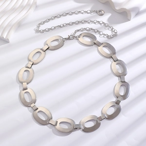 Close-up of bohemian silver metal chain belt with oval hollow links on artistic white background