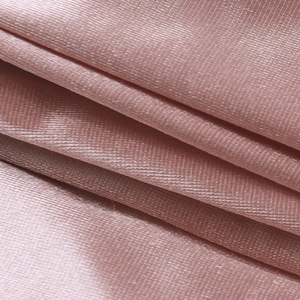 Dettaglio del tessuto in raso rosa che mostra la texture liscia e le eleganti arricciature