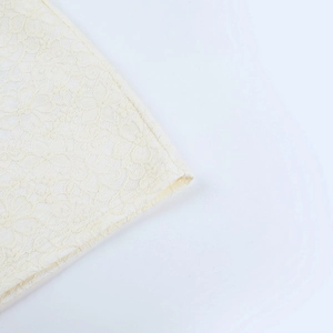 Détail rapproché de la dentelle florale élégante d'une robe d'été blanc crème