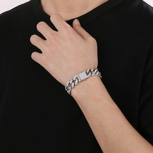 Detail of silver Cuban link bracelet with micro-pave rhinestones on a wrist