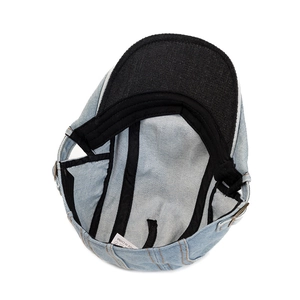 Detail view of the interior lining and sweatband of this blue denim newsboy cap