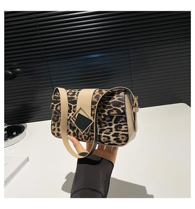 Detail of leopard print crossbody bag with beige leather strap and gold diamond buckle