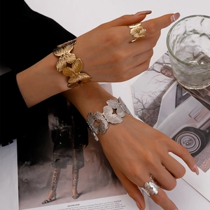 Close-up of golden and silver hollow butterfly bracelets on woman's wrist