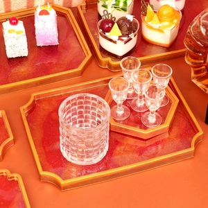Detail of red resin octagon trays with gold metal edges for elegant home storage
