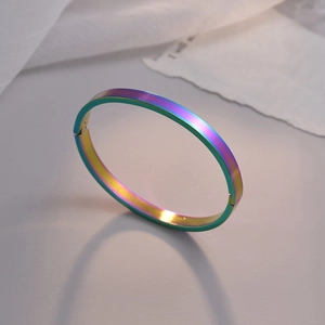 Detalle artístico de brazalete de acero inoxidable irisado con suave tul blanco