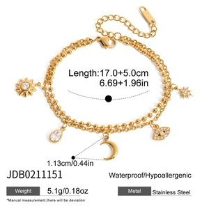 Détail du bracelet multicouche en acier doré avec breloques lune et œil de protection
