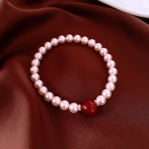 Gros plan de perles roses et d'agate rouge sur tissu en soie avec éclairage doux