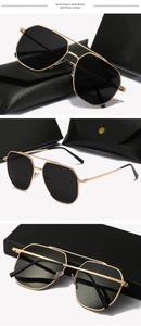 Detail view of gold metal frame sunglasses with dark grey lenses and leather case