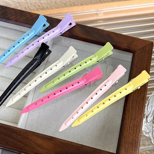 Detailed top view of colorful plastic hair clips arranged in a wooden display tray