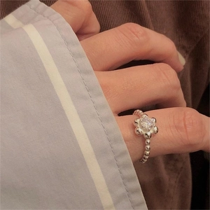 Close-up of 925 silver ring featuring a zircon flower and beaded band design