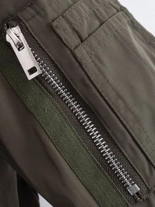 Detail of army green bomber jacket with metal zipper and high-quality fabric texture