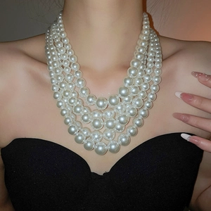 Close-up of a French style multi-layer white pearl necklace set on model neck