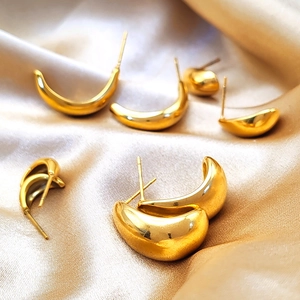Minimalist gold-plated stainless steel teardrop stud earrings on champagne silk fabric