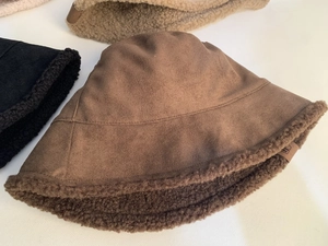 Detail of multi-color suede bucket hats showing thick lamb wool lining and small side tags