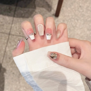 Faux ongles œil de chat champagne avec perles et design french manucure blanche