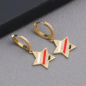 Macro shot of gold star earring with micro-pave crystals and colorful striped enamel