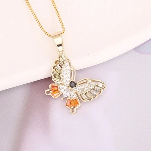 Macro shot of copper butterfly pendant with colorful cubic zirconia inlays and gold plating
