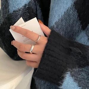 Détail de bagues ajourées en argent sterling 925 superposées sur la main d'un modèle