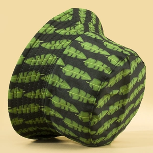 Double-sided bucket hat with green banana leaf pattern on black canvas for sun protection
