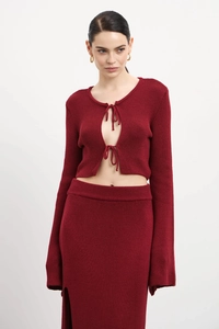Détail de l'ensemble en tricot bordeaux avec haut à nouer et texture de la jupe longue