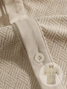Close-up of khaki textured waffle jacquard fabric and buttons on a men's short sleeve shirt