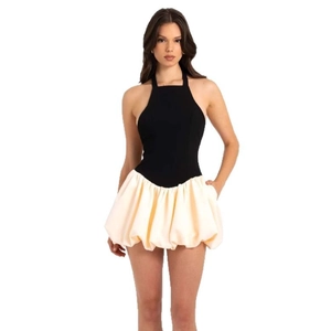 Modisches rückenfreies Neckholder-Kleid mit schwarzem Top und cremefarbenem Puffsaum