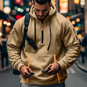 Detail of khaki fleece-lined tactical hoodie featuring orange-trim kangaroo pocket