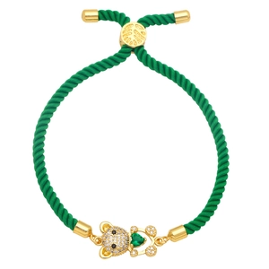 Detail view of woven green cord bracelet with crystal bear charm and green heart stone