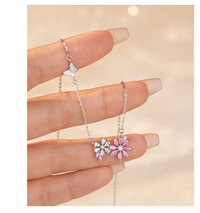 Close-up of S925 silver necklace with pink and white flower charms and butterfly pendant