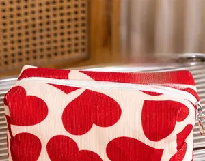 Close-up of heart pattern corduroy makeup bag with a gold heart-shaped zipper pull