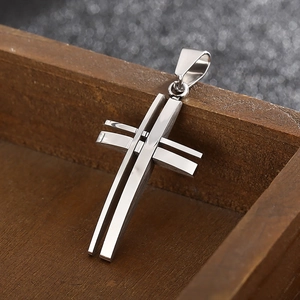 Detailed view of a silver hollow layered stainless steel cross pendant in a wooden gift box